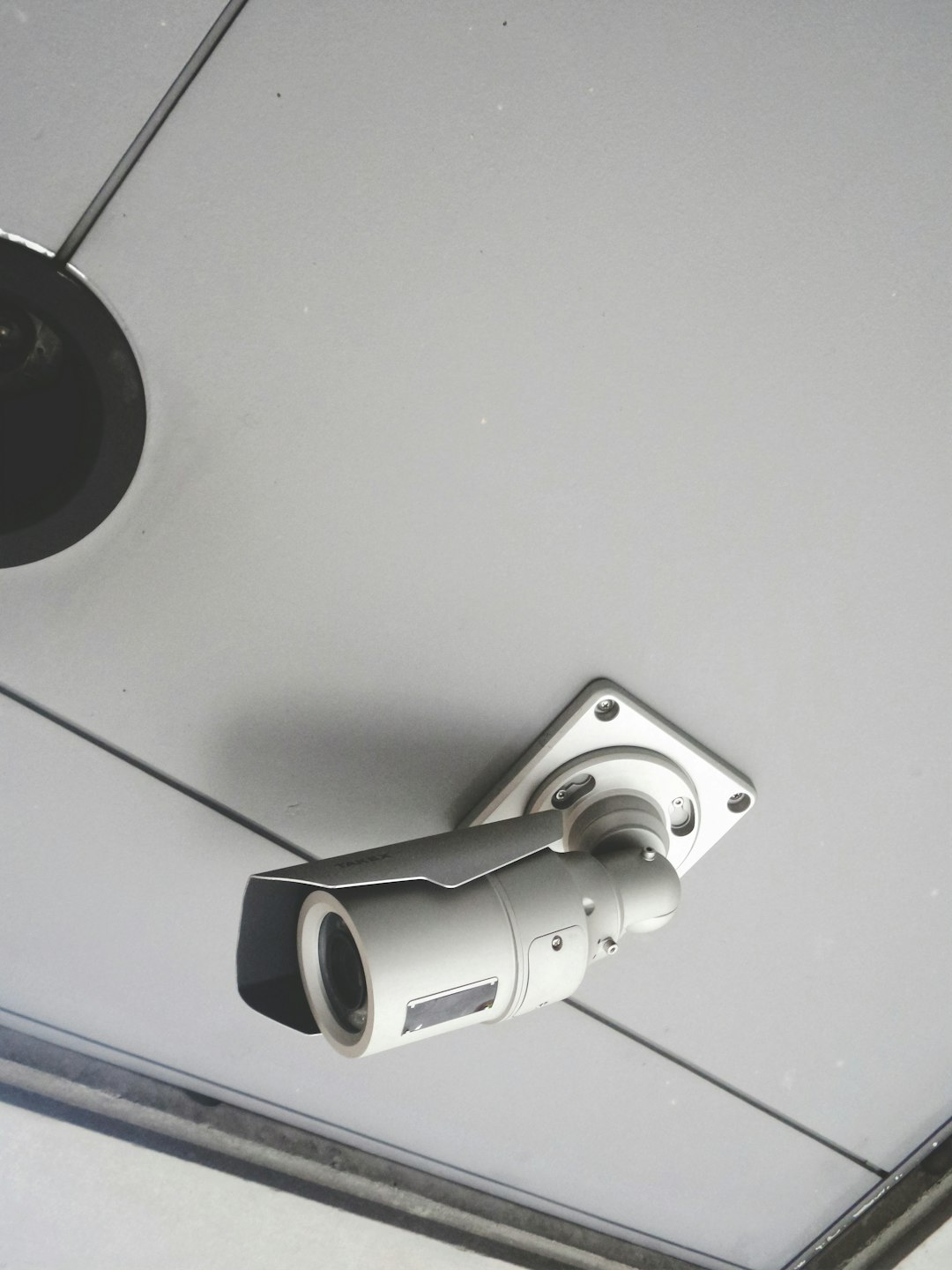 a-security-camera-mounted-to-the-ceiling-of-a-building-ujssik5izma